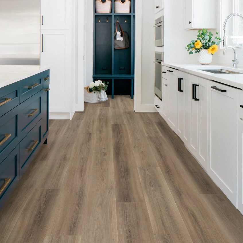 Modern kitchen with wooden flooring, white cabinets, and blue island and blue entry cabinets. White quartz countertops.