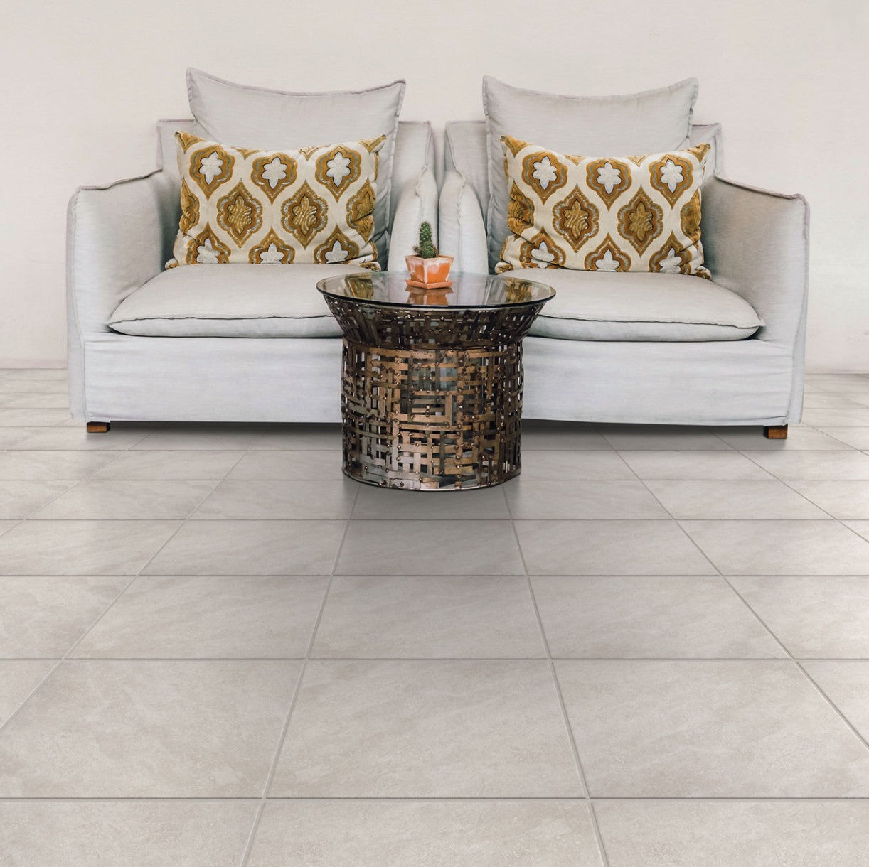 Gray sofa with patterned cushions and a decorative table on a tiled floor. Dal Tile Choice Iron 13" x 13" floor tile