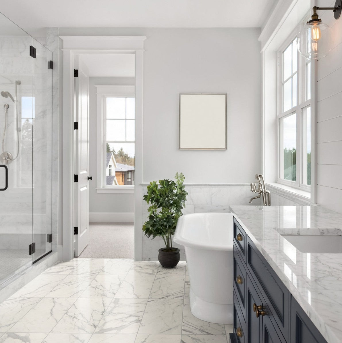 Modern bathroom with white marble floor, freestanding bathtub, and dark wood cabinets.