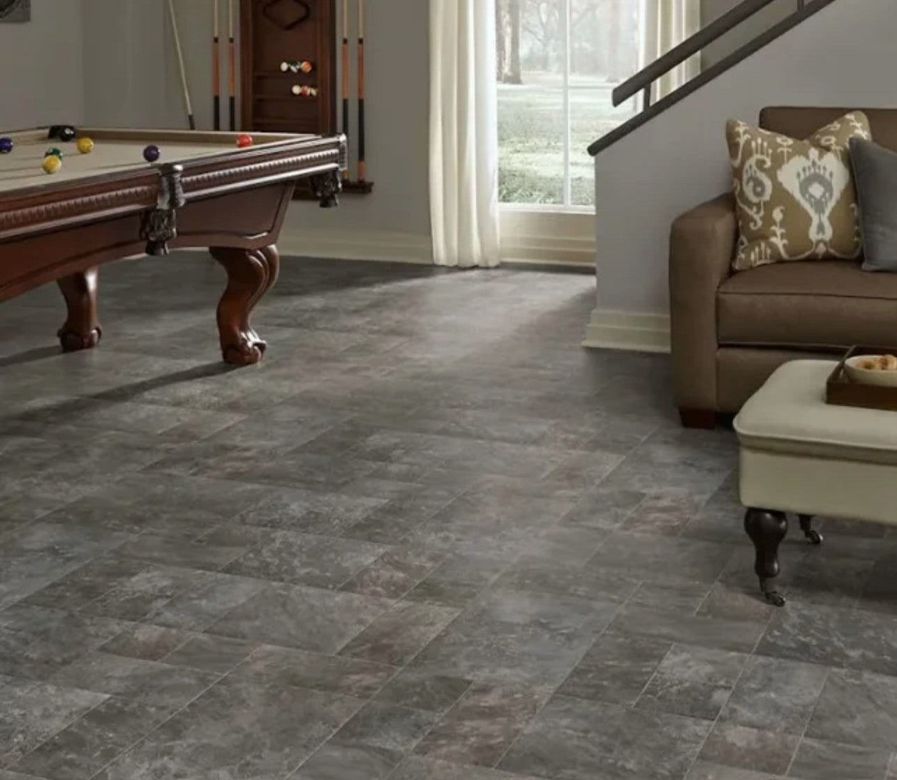 Living room with slate-style flooring, pool table, and sofa.